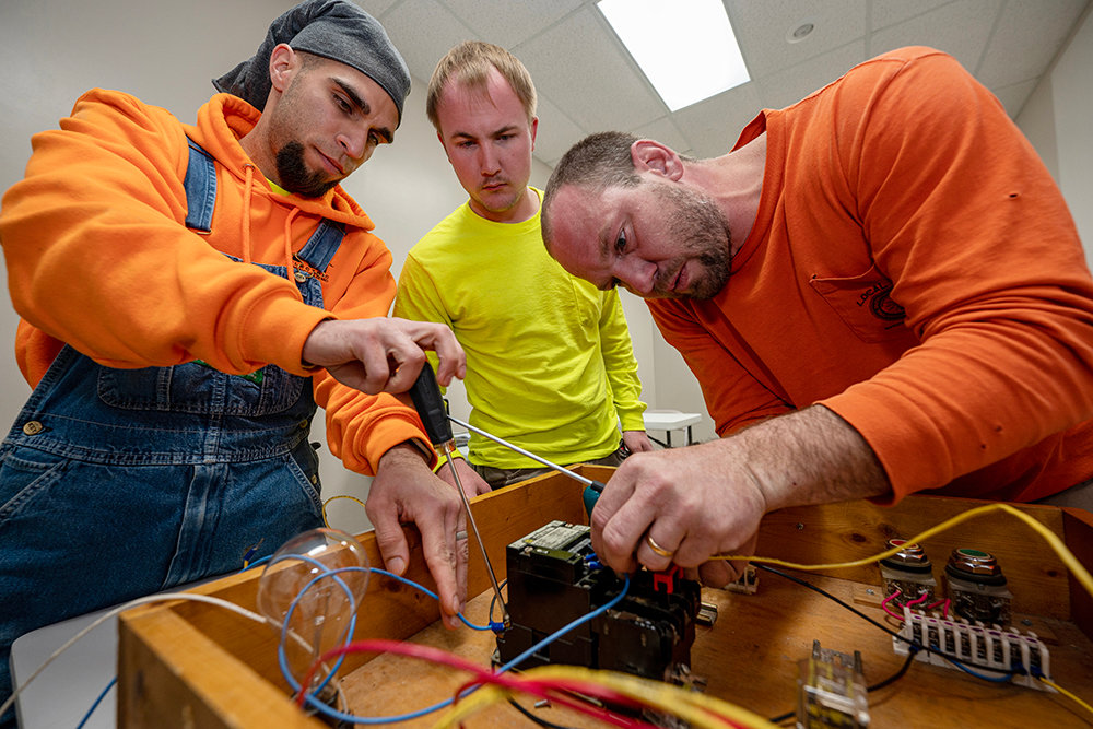 Fourth-year electrician apprentices assemble wiring for a motor control circuit during a class at IBEW Local 453 in Springfield. Pictured, from left, are Rico Berry, Matt Spohn and Mike Malas.